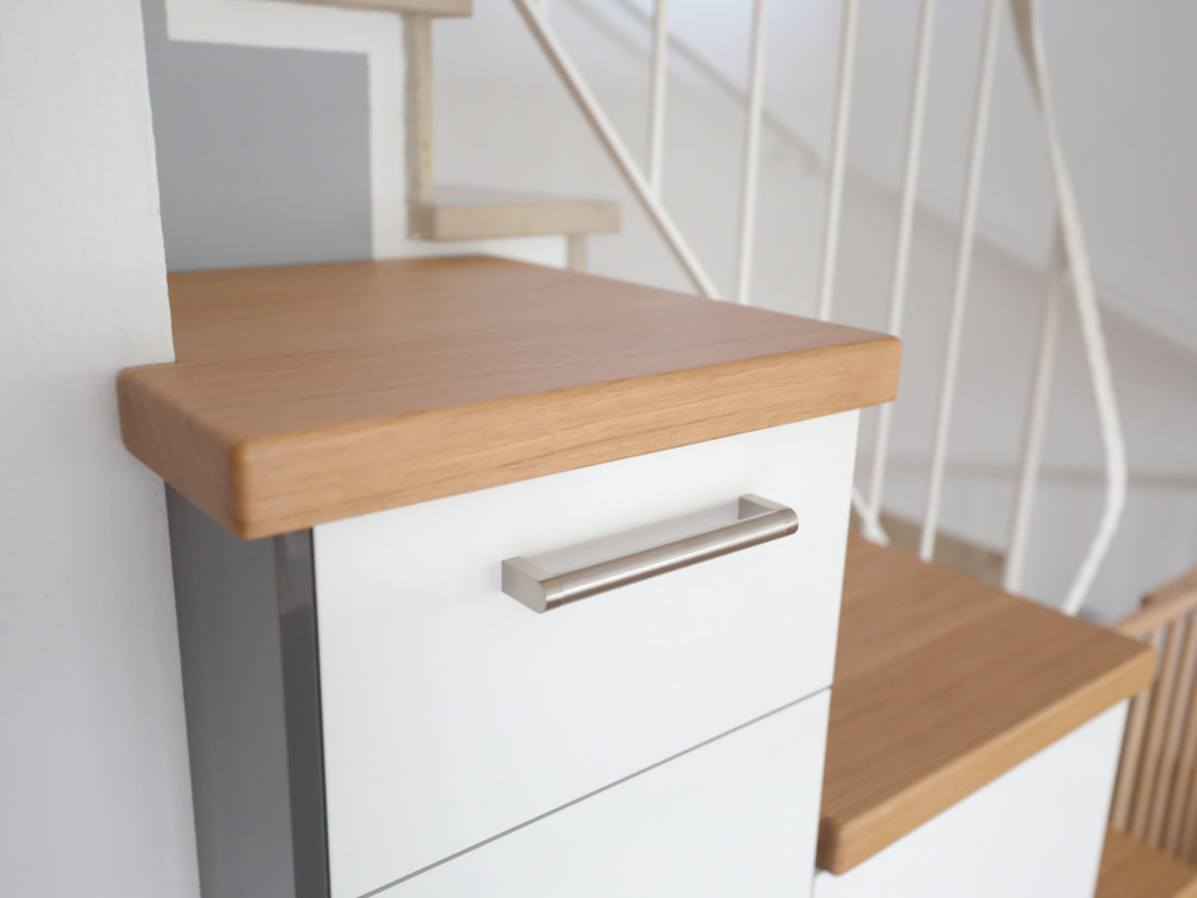 Für diesen Küchenschrank von RUPPERTdesign wurde geöltes Eichenholz verwendet. Die Front ist weiß glänzend mit grau glänzenden Seiten.